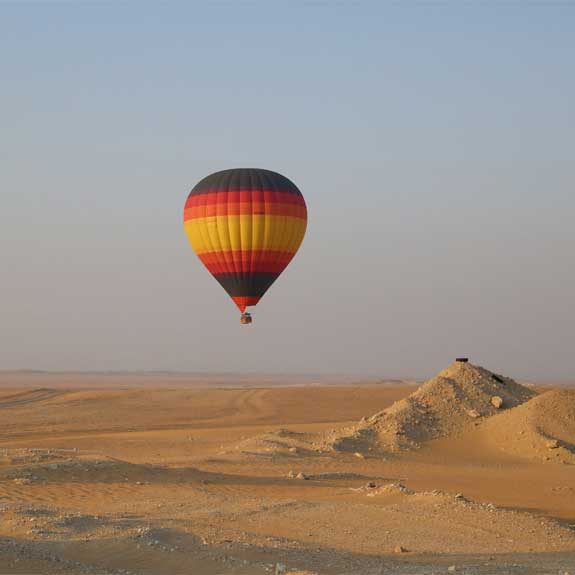 A Bright Hot Balloon Gliding Over The Desert During Hot Air Balloon Ride Dubai.